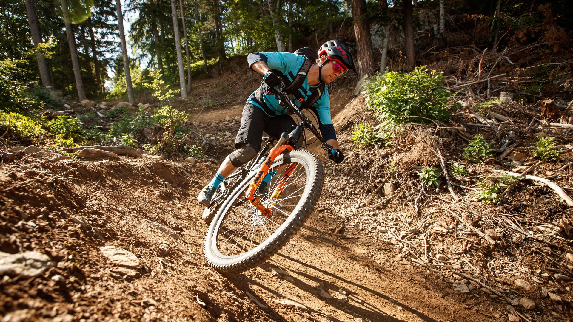 Abenteuer auf Mountainbikes Mountainbiker auf Waldpfad in actionreicher Kurve bei sonnigem Wetter.